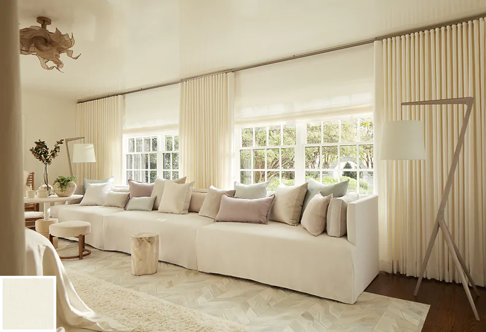 From the couch to the ripple fold drapes, this cream-colored monotone look provides more living room curtain ideas