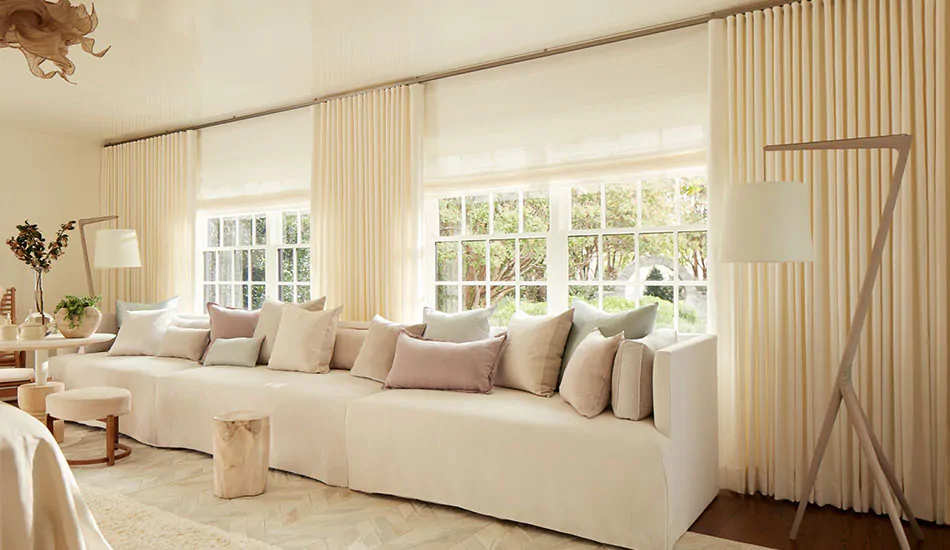 A monotone living room with cream colors features Ripple Fold Drapery in a float length made of Heathered Linen in Ivory