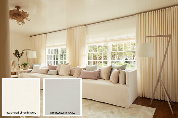 One of the colorful window treatment trends 2024 is the use of warm whites and ivory seen on these living room drapes