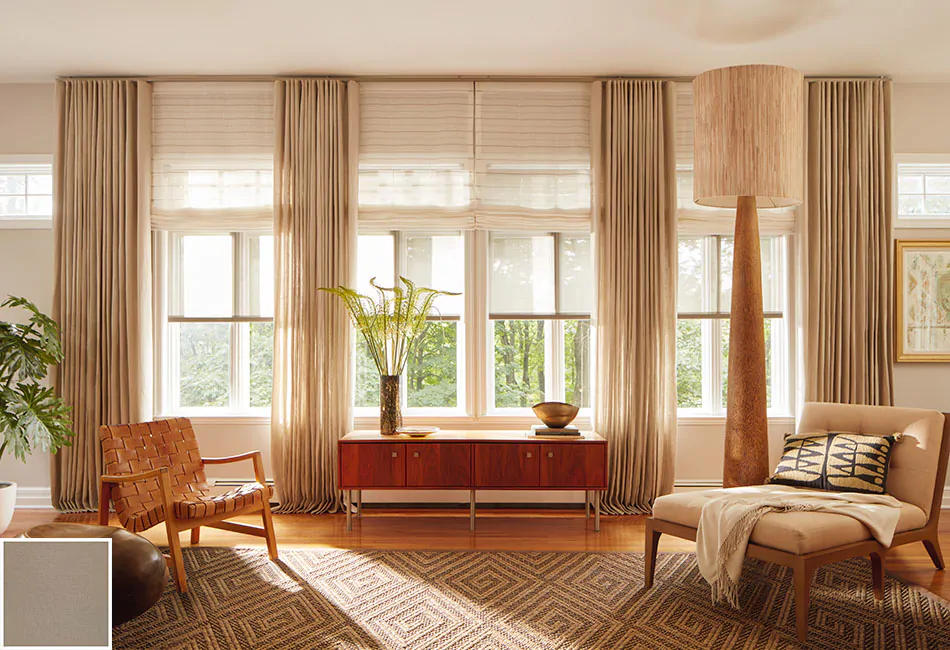 Curtain ideas for living rooms include this wood-toned space that benefits from complementary beige drapes and a tall lamp