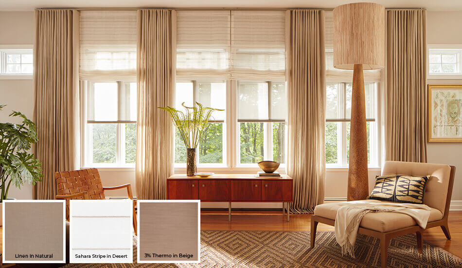 One of the window treatment trends 2024 is layering different styles as seen in this living room's drapery and shades