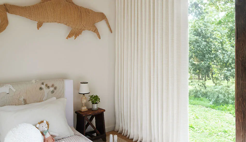 Light colored drapery like Claude Stripe in Alabaster in a kids room is a good choice for curtains to keep heat out.