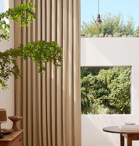 Neutral colorful curtains made of Surrey Stripe in Morel and Natural add a warm hue and lush texture to an earthy living room