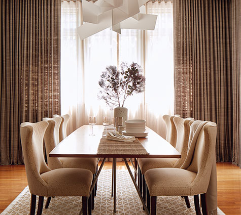 Layering styles, one of the window treatment trends 2024, is seen in this dining room's two layers of Ripple Fold Drapery
