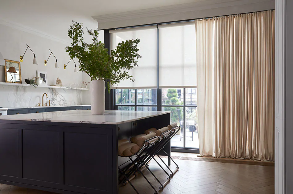 One example of drapery styles is featured in a kitchen with a large island and ripple fold drapery in a cream color