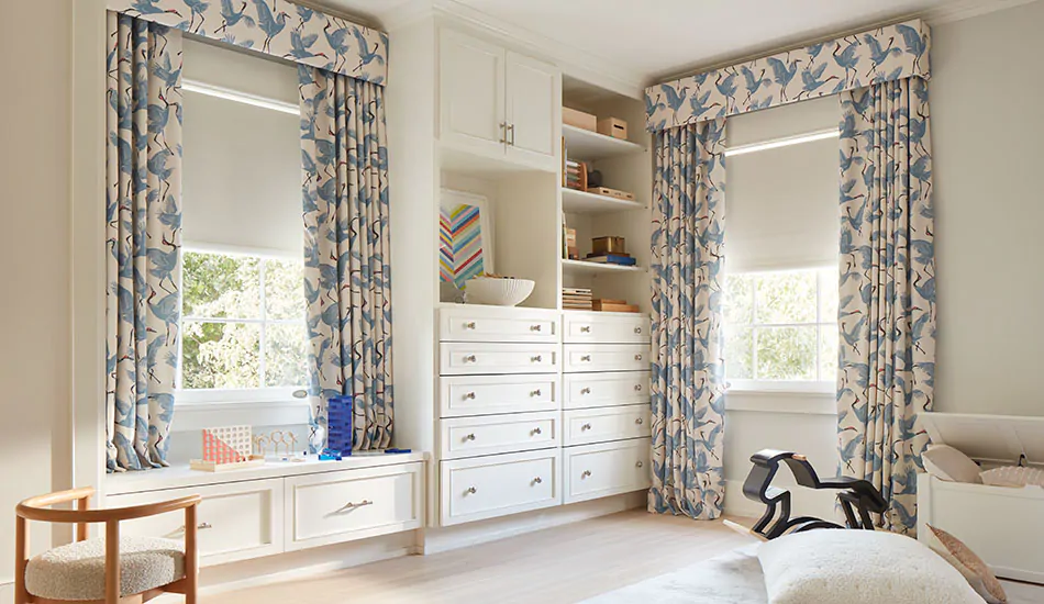 Nursery window treatments include Ripple Fold Drapery in Family of Cranes, Waverly Blue and Roller Shades in Ava in Birchwood