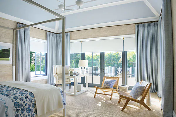 Transitional window treatments balance feminine and masculine elements like blue Tailored Pleat Drapery & white Roller Shades