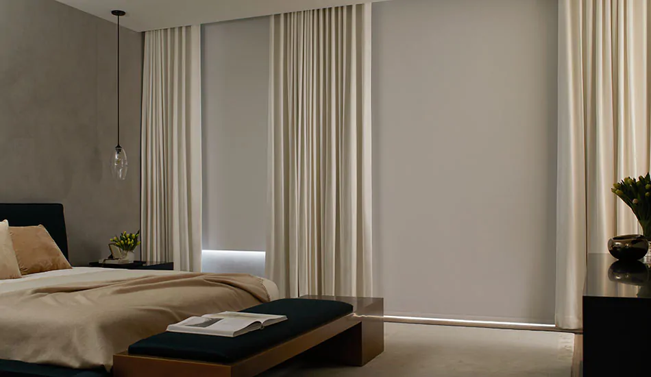 A darkened bedroom with blackout Roller Shades shows the difference in light control between Solar Shades vs Roller Shades