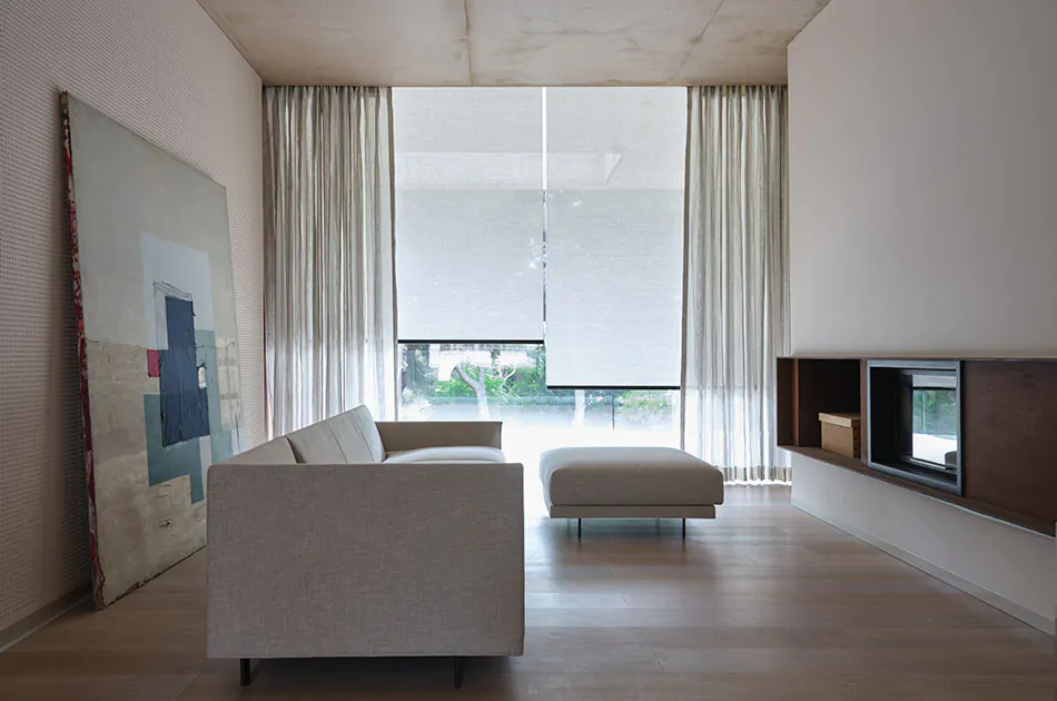 Minimalist window treatments in a modern media room include Roller Shades and Tailored Pleat Drapery cool off-white colors