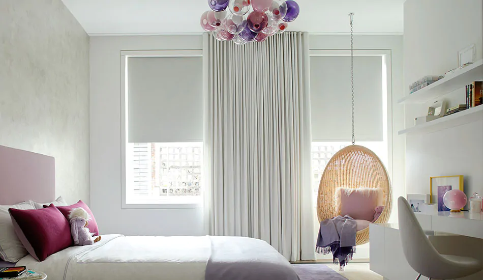 A girl's room features kids curtains in a neutral Wool Flannel Glacier and pops of pink and purple in the bedding and décor