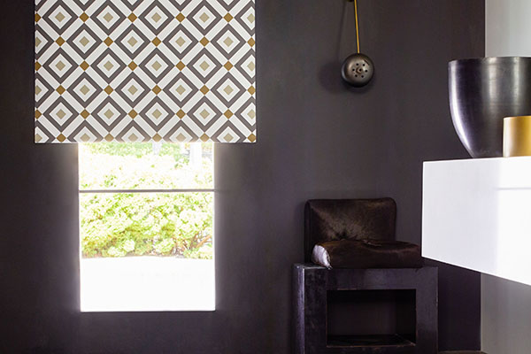 A Roller Shade made of Vionnet Blackout in Pewter offers excellent bathroom window privacy in a modern black bathroom