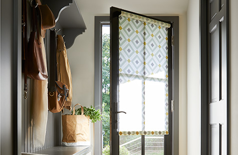 Front door window coverings with patterned Roman Shades on a glass entry door.