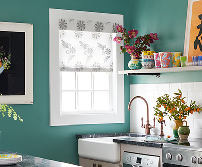 A Cordless Roller Shade made of Florentine in Grigio in a turquoise kitchen shows one style of pull down window shades