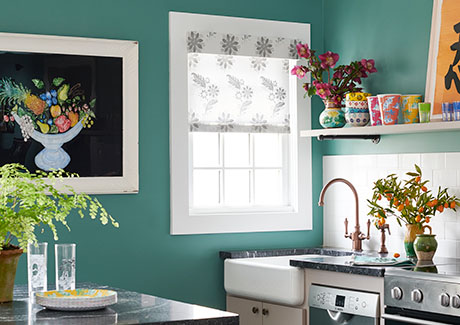 A kitchen with turquoise walls features a Roller Shade made of Sheila Bridges Florentine in Grigio for a subtle pattern