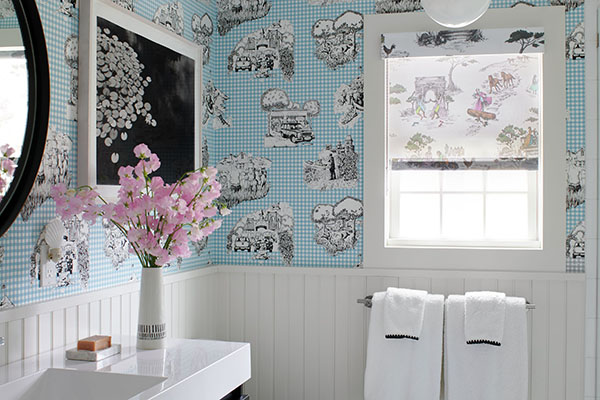 A Roller Shade made of Harlem Toile De Jouy in Multi White offers bathroom window privacy in a pop-art-inspired bathroom
