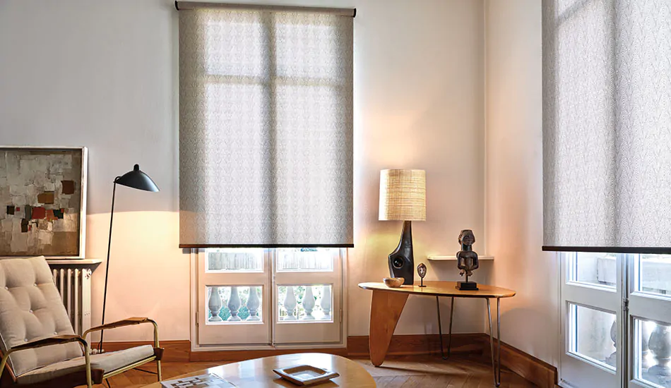 A mid-century modern living room has wood furniture, accent lighting and Roller Shades made from Tea Leaves material in Brown