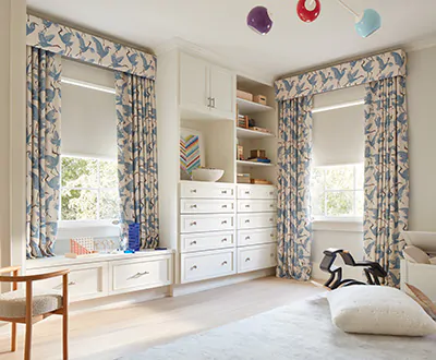 A kids room features Ripple Fold Drapery with a cornice, all made from Family of Cranes material in Waverly Blue