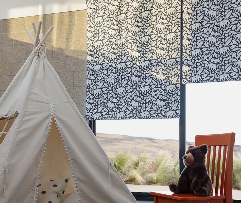 A nursery with a teepee set up has blackout shades for nursery windows made of Roller Shades in Eleo, Navy