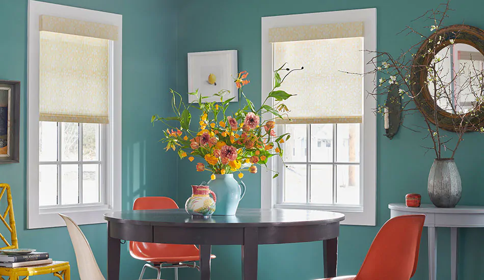 A room painted turquoise features sleek Roller Shades with a hard valance showing the difference between a cornice vs valance