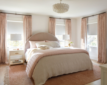 Windows in bedroom featuring Tailored Pleat Drapery in material Chinoiserie and color Blush with large pink and white bed