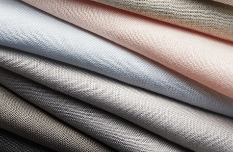 Linen fabric in different colors is folded neatly and features a soft texture for linen Roman Shades