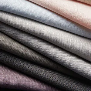Roman Shade swatches made of Linen fabric are folded and stacked tightly and show the texture and soft colors