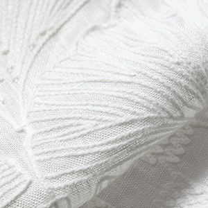 A swatch of The Novogratz Feather Palm Embroidered shows the intricate gingko leaf design on a delicate material