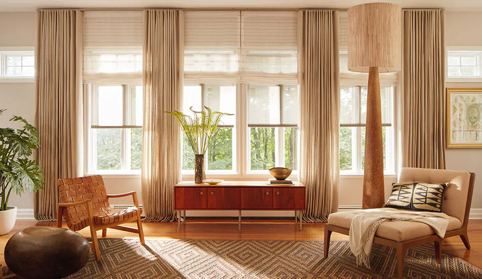 A warm, inviting room features three layers of window coverings including Solar Shades, Roman Shades and Drapery