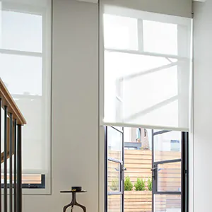 A bright entryway has light filtering Roller Shades that showcase the difference between blinds vs shades
