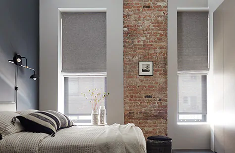Roman Shades made of Heathered Linen in Smoke are used as window treatments for large windows in a modern bedroom