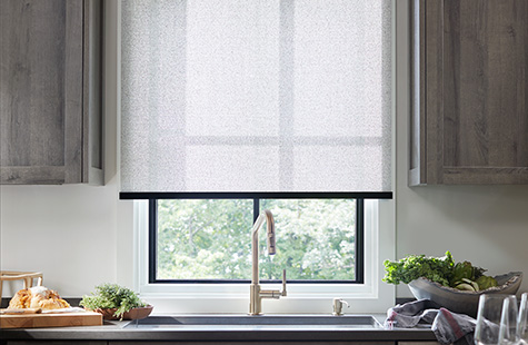 To compare light filtering vs blackout a kitchen has a Solar Shade of 3 percent Solistico in Ash which brightens the room