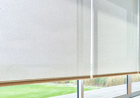 Wide panels of solar Shades made of 10 percent material in Beige cover tall, wide windows in a modern space