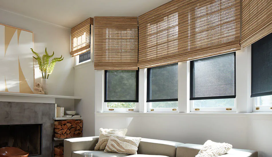 Woven wood shades and solar shades replace bow window curtains on windows in an inviting basement family room