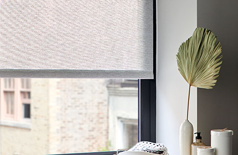 A close-up of lighter solar shades in a bathroom illustrating their see-through quality while also obscuring what's inside