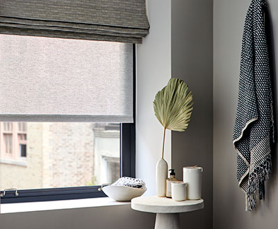 An example of solar shades for windows, this time in a modern bathroom with an outer layer of a flat roman shade