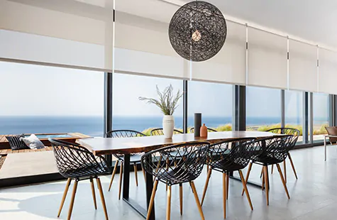 Solar Shades made of 5% in Grey are used as window treatments for large windows that span wall to wall in a dining room