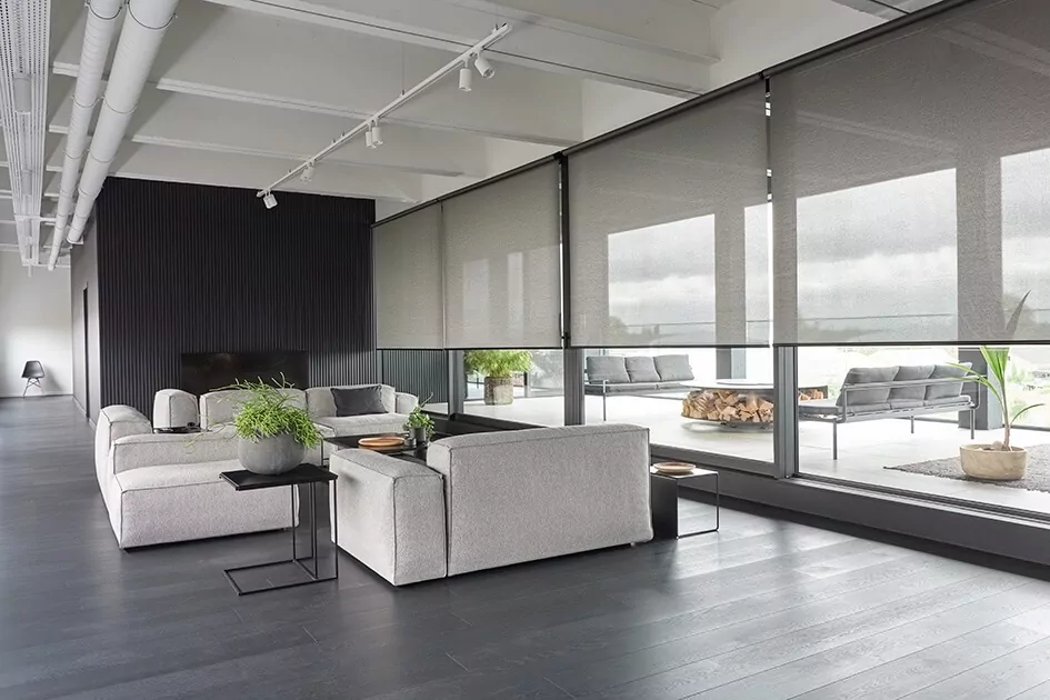 A large modern living room with huge panels of glass doors features roller shades for sliding glass doors 