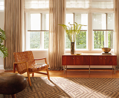 White solar shades for windows combined with flat roman shades and ripple fold drapery in a mid-century modern living room