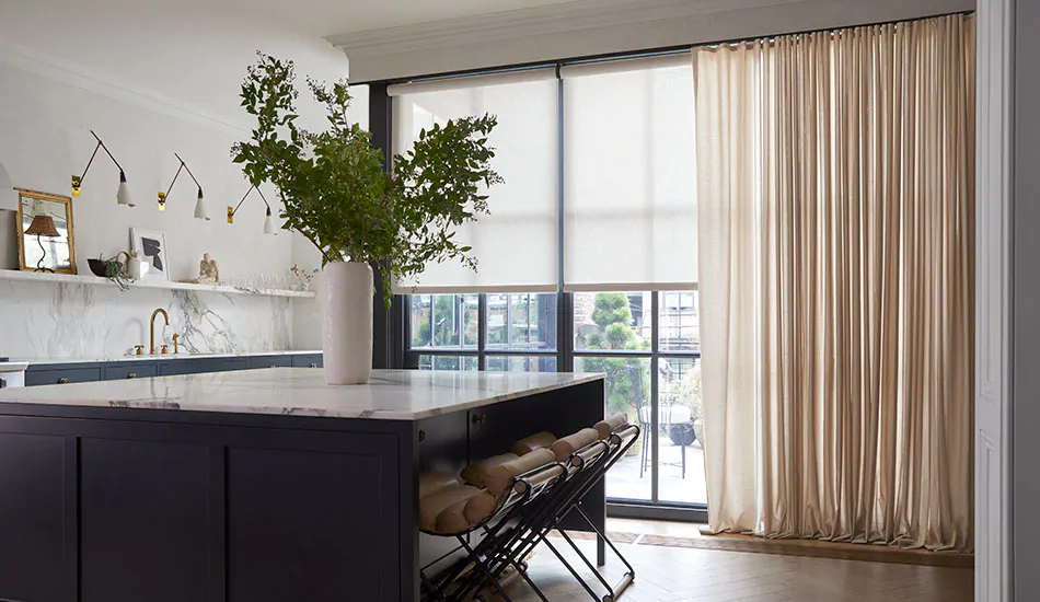 Modern window treatments in a kitchen include warm-toned drapery over floor-to-ceiling windows with beige solar shades