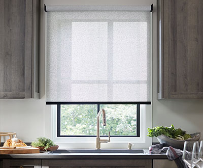 A Cordless Solar Shade made of Sunbrella 3% Solistico in Ash in a grey kitchen shows one style of pull down window shades