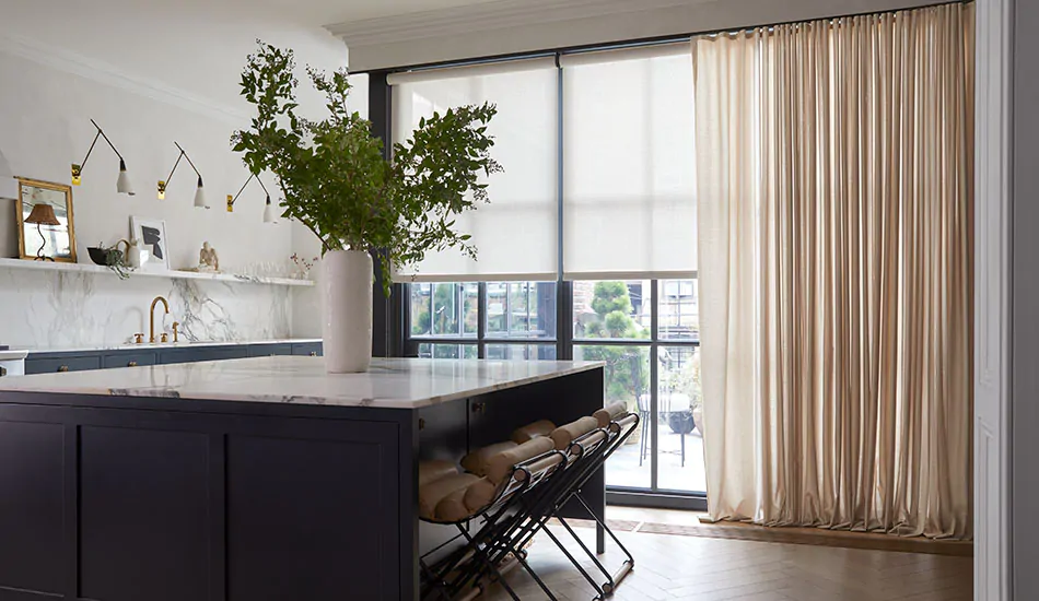 An elegant kitchen with ripple fold drapery over solar shades helps answer the question what is a solar shade