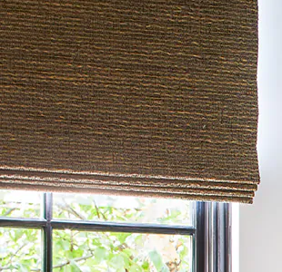 A close up of a Woven Wood Shade made of Beacon in Cinder with blackout lining shows no light filtering through