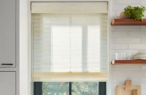 Bamboo blinds made of Coastline in Muslin filter light into a modern farmhouse kitchen with open wood shelves