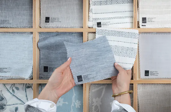 A woman holds swatches in her hand, pulled from a draw made specifically for swatches in a showroom