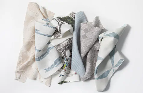 Swatches piled invitingly on a table from the new designer collection by Sheila Bridges feature subtle texture and patterns