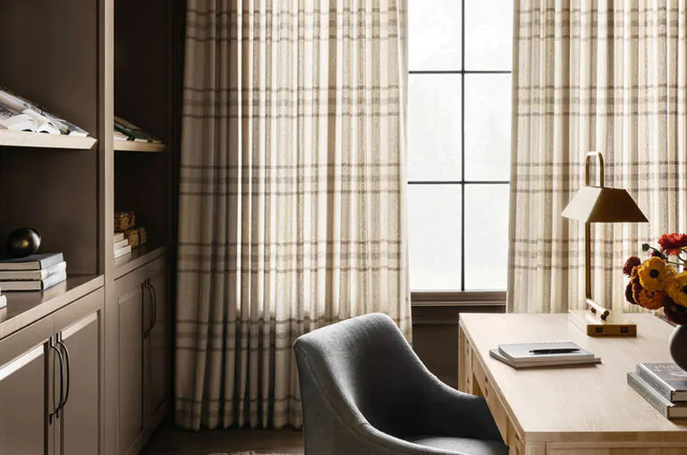 Long floor-to-ceiling plaid curtains adorn a contemporary office setting with built-in shelves behind an office desk