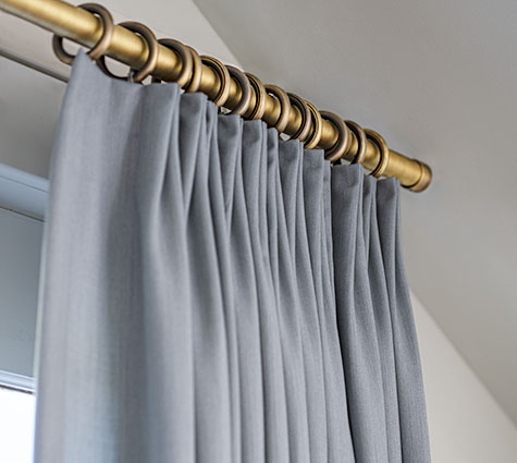 A close-up of Tailored Pleat Drapery with Steel Hardware shows there is little difference between drapes vs curtains