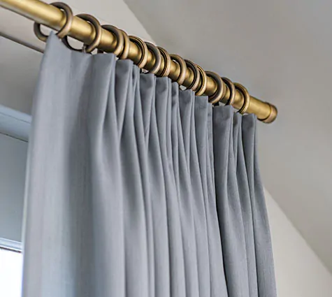 A close-up of Tailored Pleat Drapery with Steel Hardware shows there is little difference between drapes vs curtains