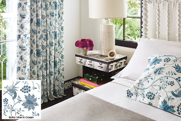 Floral patterns, one of the window treatment trends 2024, is seen in this bedroom's Boho Vine in Ocean Tailored Pleat Drapery