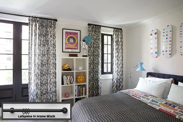 A kids room has French return rods Lafayette in Matte Black with Tailored Pleat Drapery made of Daisy Bloom in Zebra Black